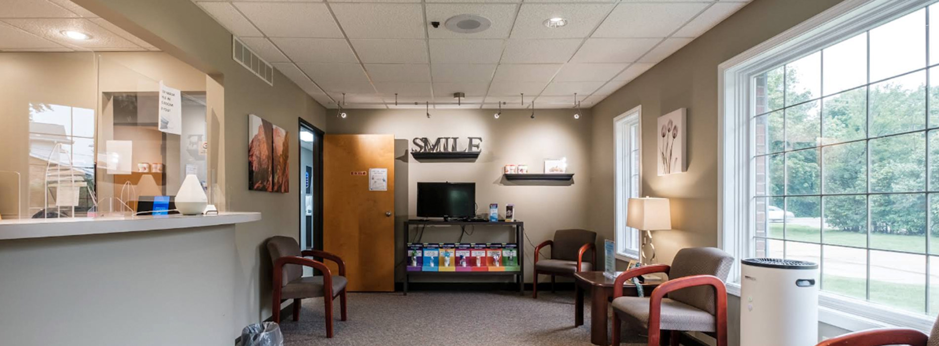 The image shows a modern dental clinic interior with various pieces of equipment, including a dental chair and an X-ray machine.