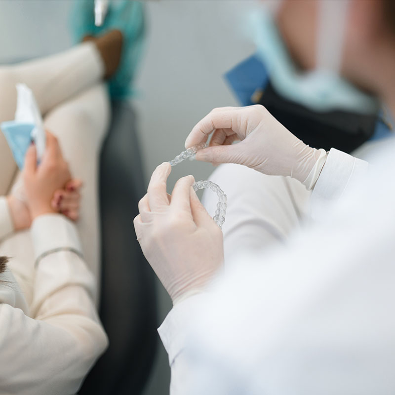 The image shows two photos side by side on the left, a person with a toothbrush in their hand inspecting a dental implant, and on the right, a dentist in a white coat and gloves using a dental tool on an implant.