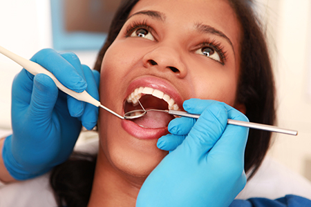 A dental hygienist performing oral care on a patient s teeth.